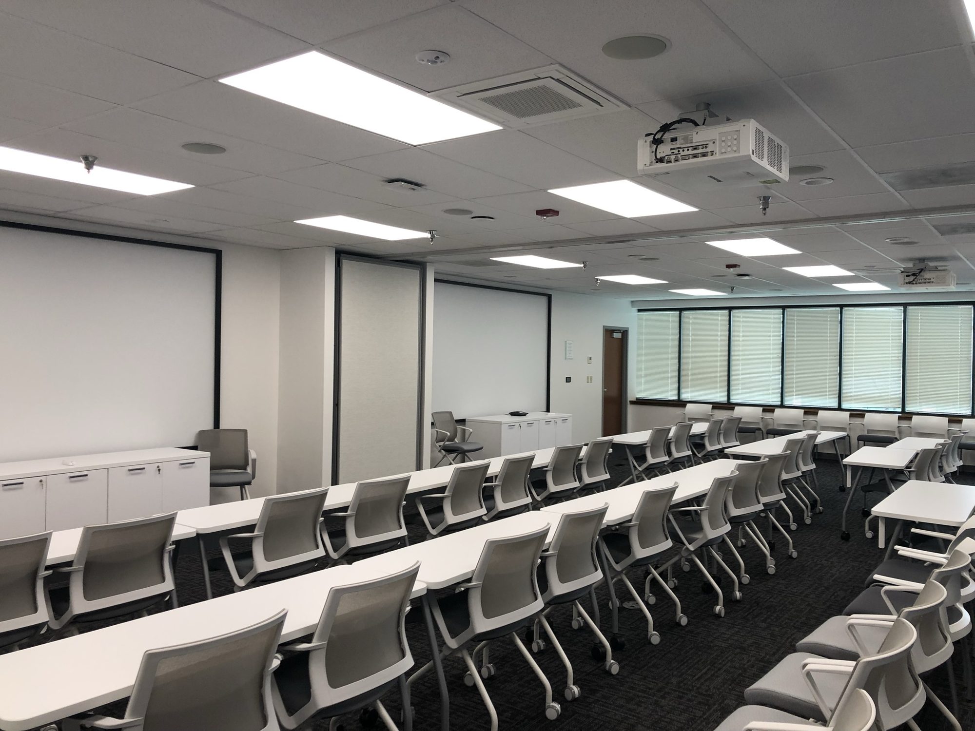 Large completed training room with presentation screens and ceiling-mounted projectors