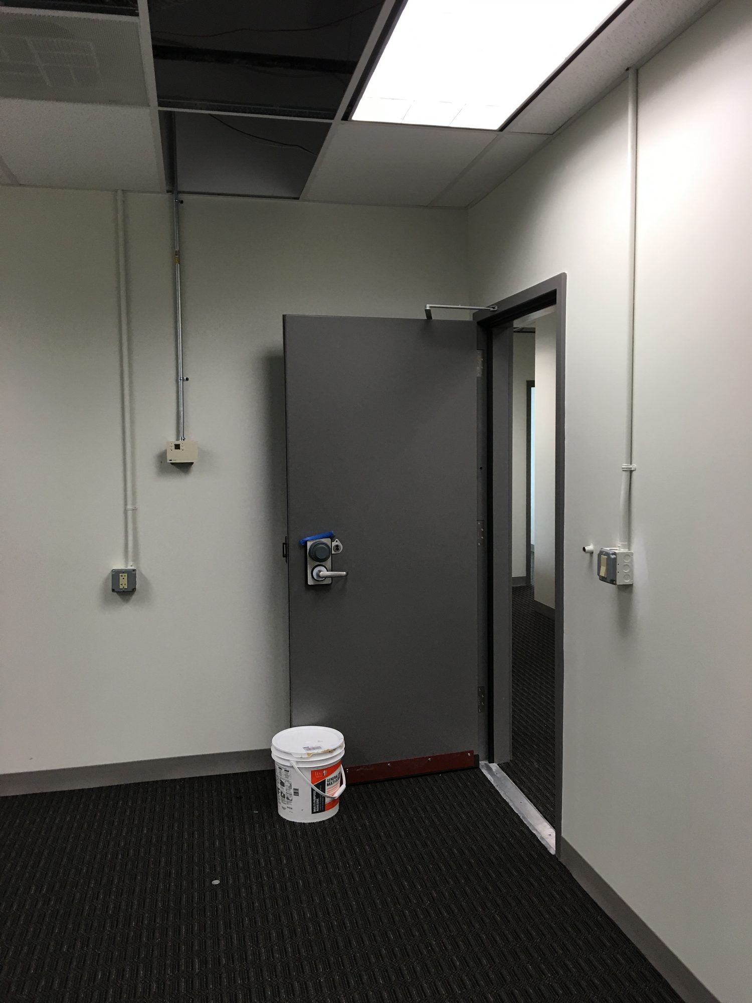 Finished controlled opening with a heavy door and surface-mounted electrical services