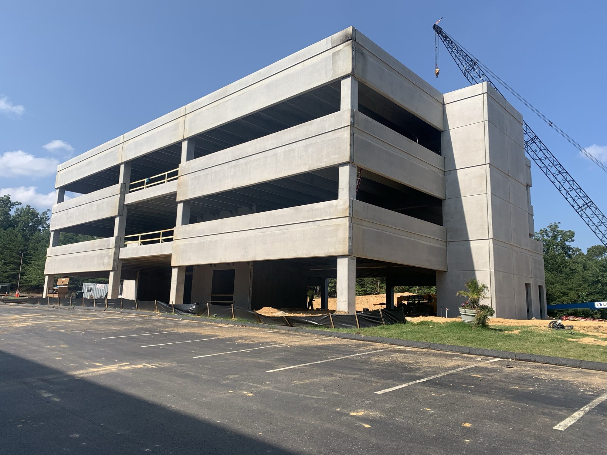 Completed concrete building structure beside newly paved parking