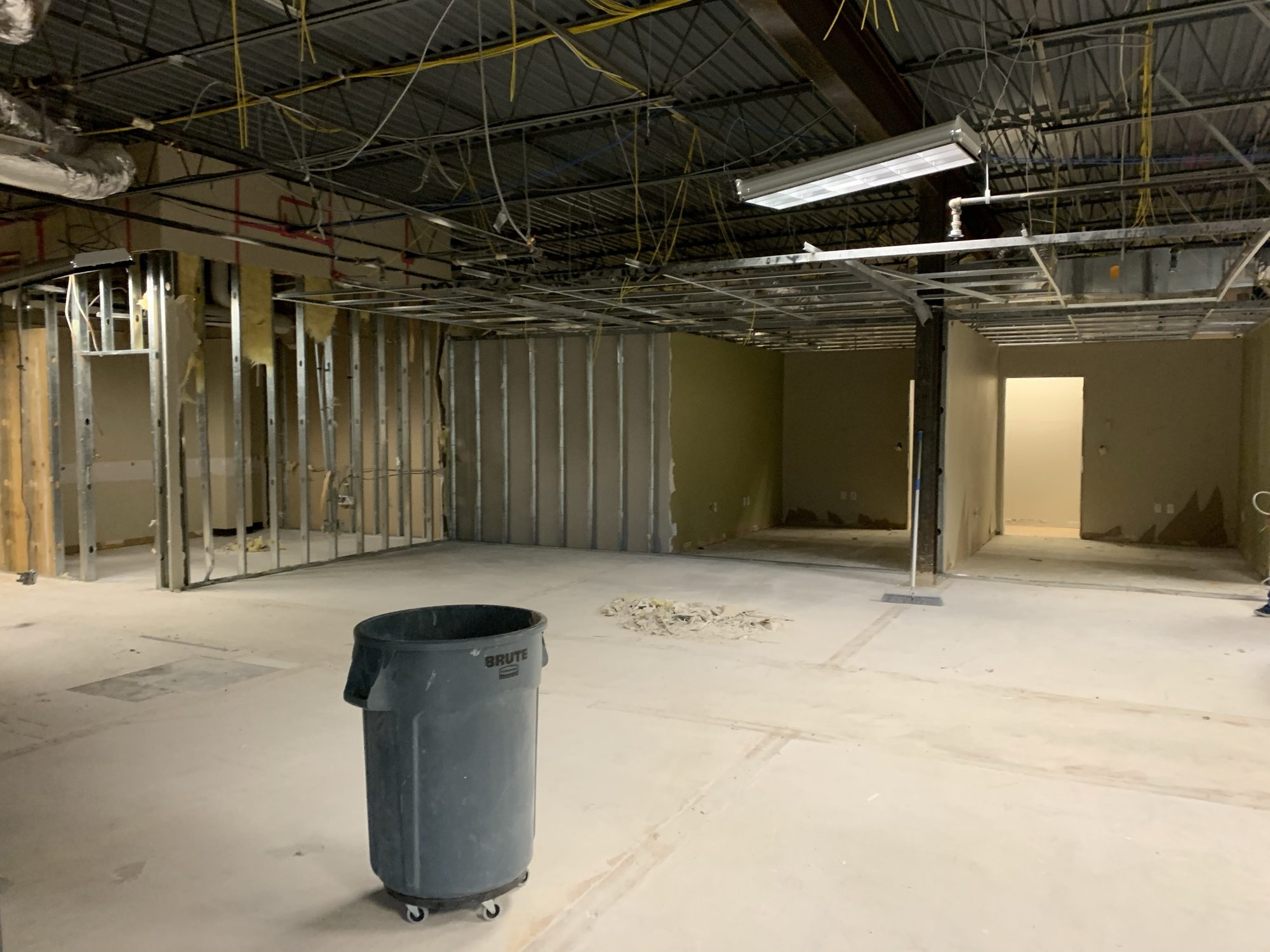 Interior renovation area after demolition with exposed ceiling and new wall framing