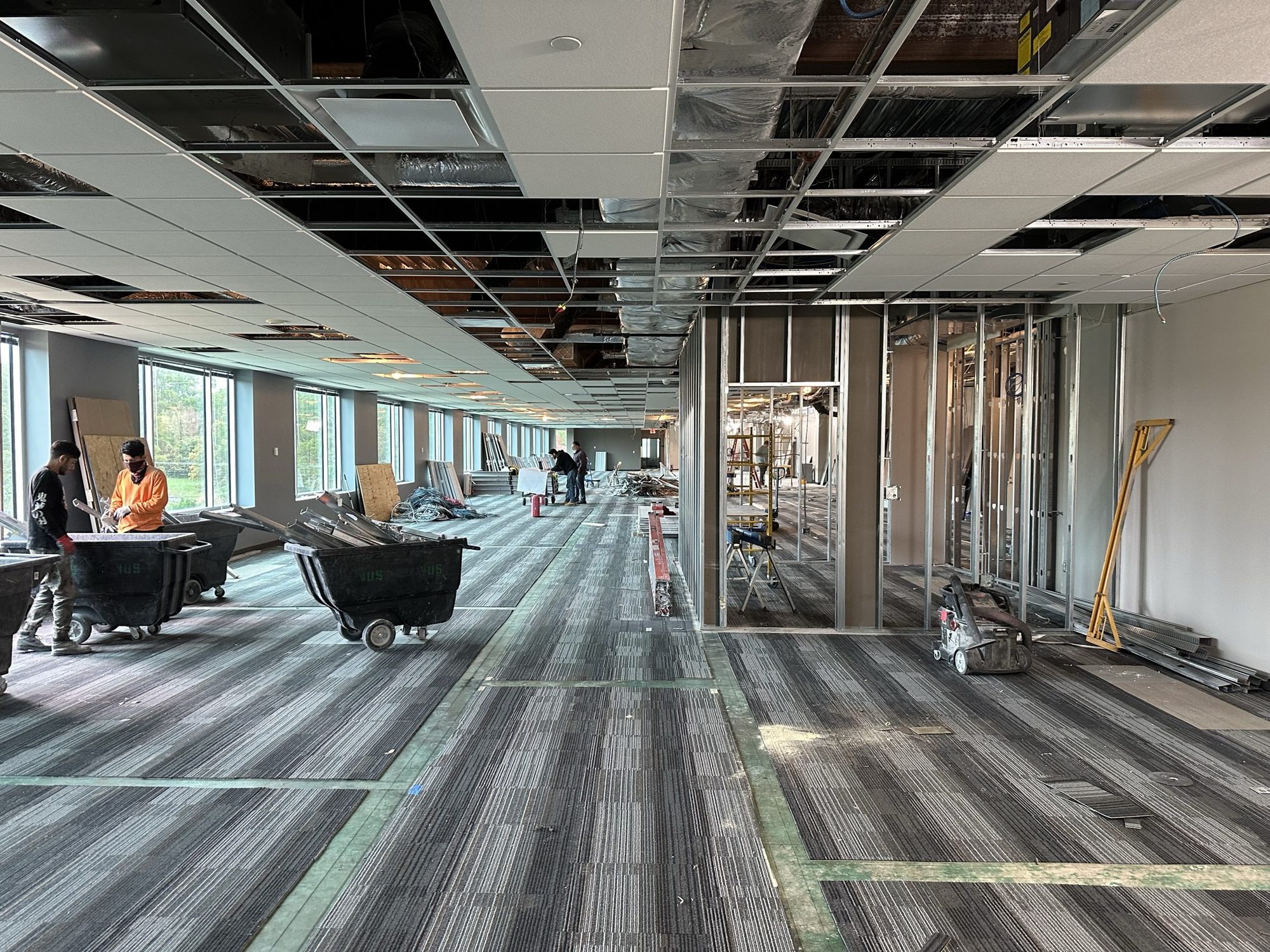 Partially finished office interior with new carpet and exposed ceiling services