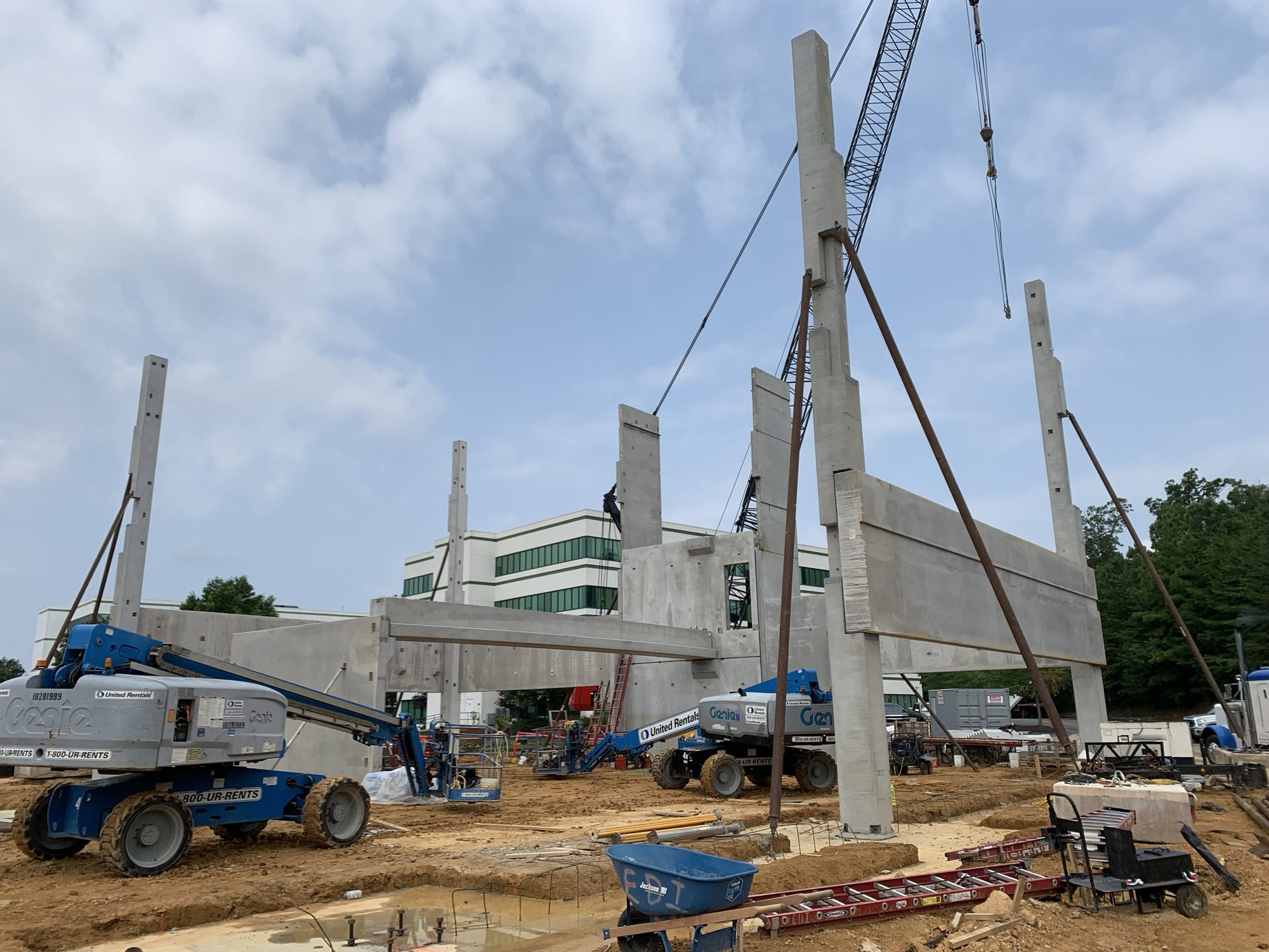 Cranes setting tall precast concrete columns at an active building site