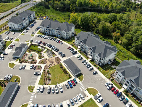 Aerial view of apartment buildings surrounding parking areas, landscaped courtyards, and walkways