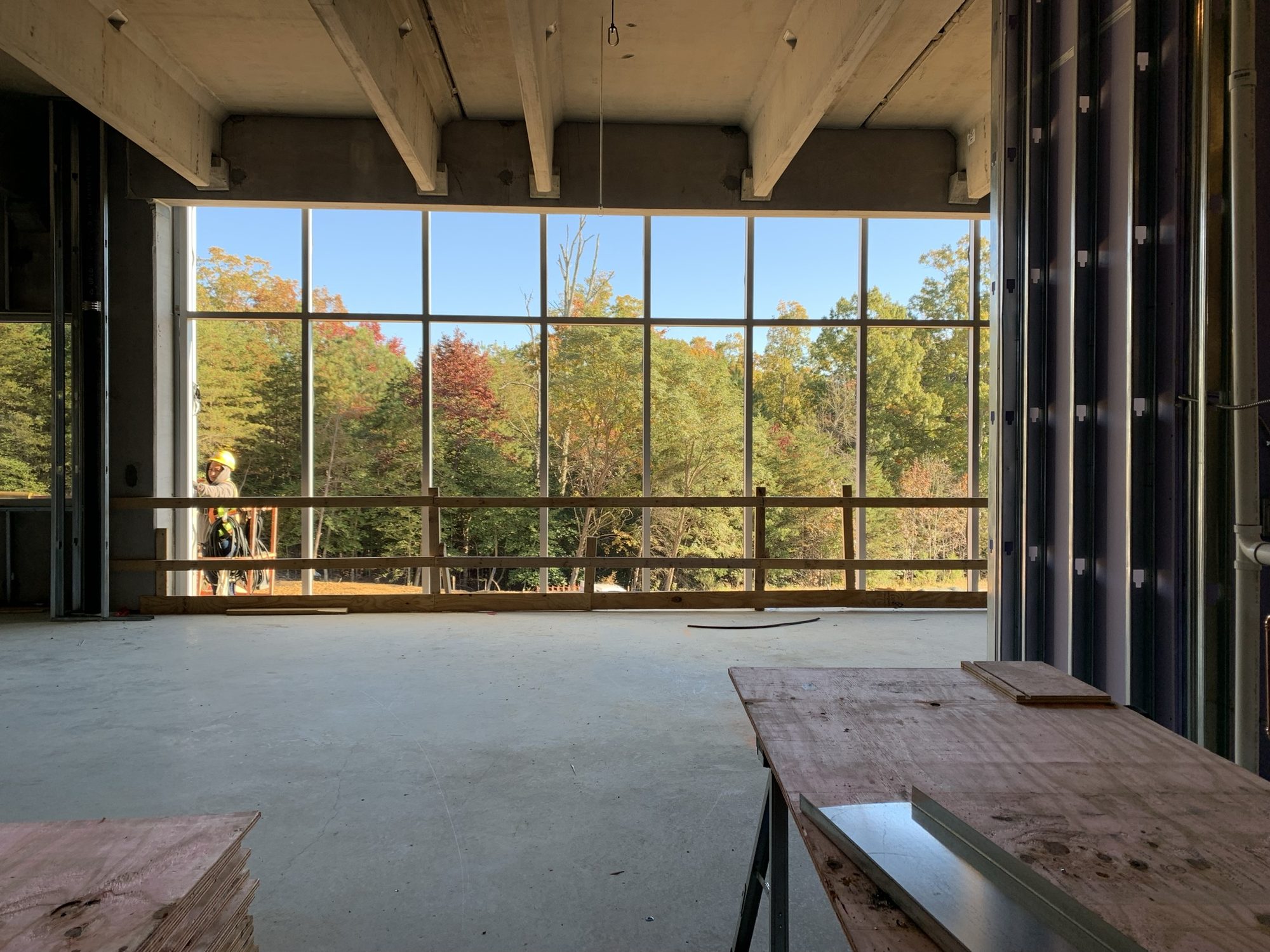 Floor-to-ceiling exterior glazing viewed from an unfinished interior
