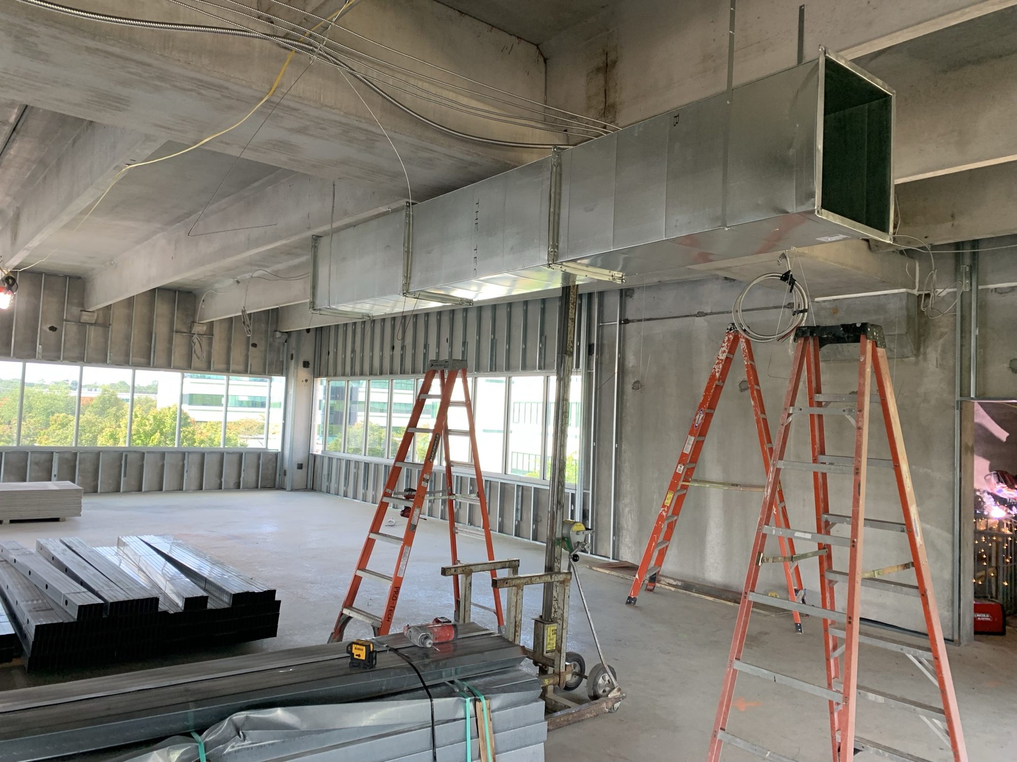 New overhead ductwork installed across an unfinished interior floor