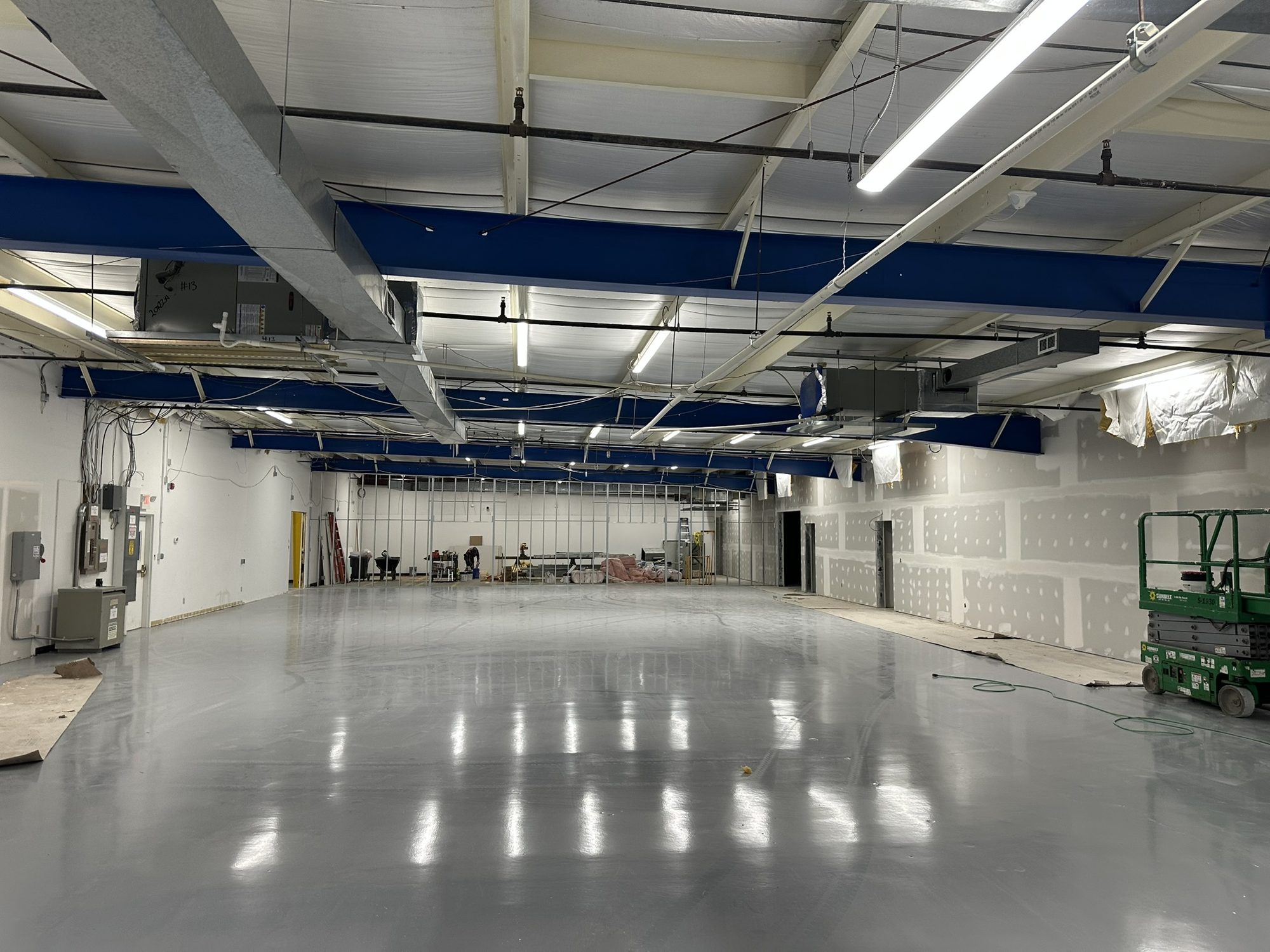 Finished high-bay interior with bright linear lighting and polished floor